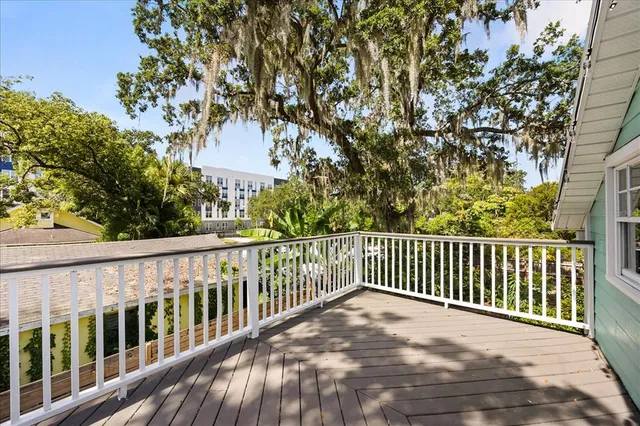 a balcony with wooden floor and trees