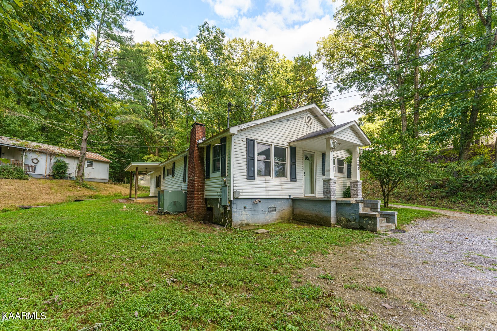a front view of a house with a yard and trees