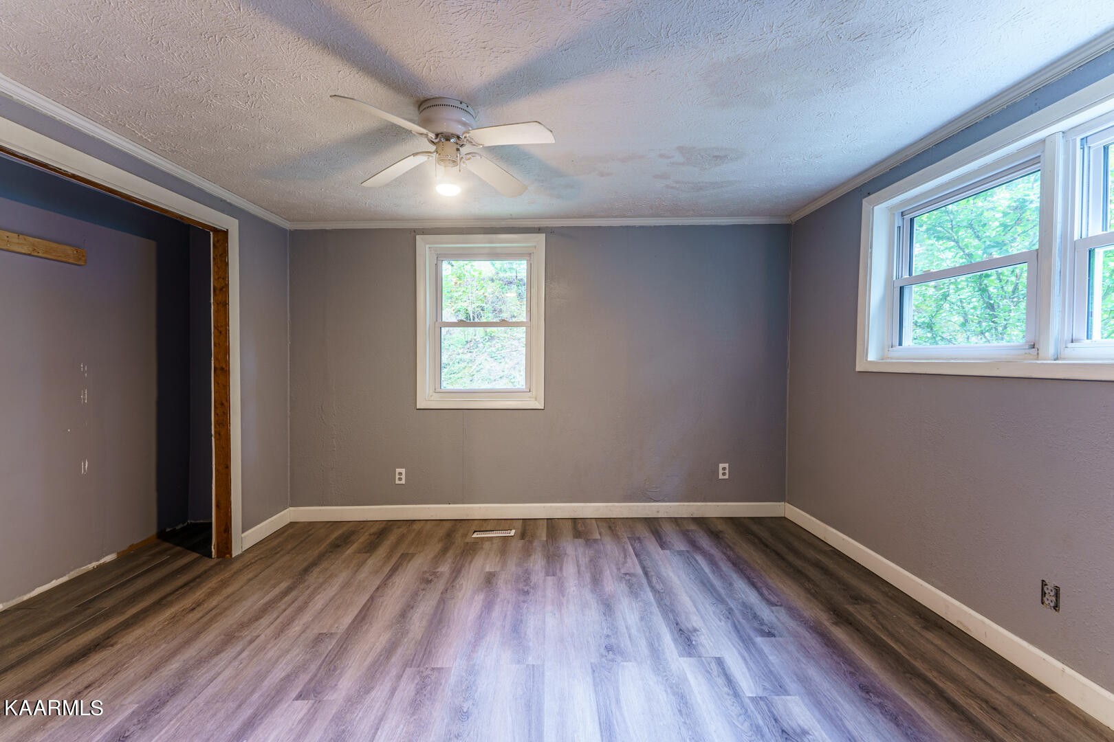 203 Duggan Road Lenoir City, TN 37771 - Photo 4 of 16 an empty room with wooden floor and windows
