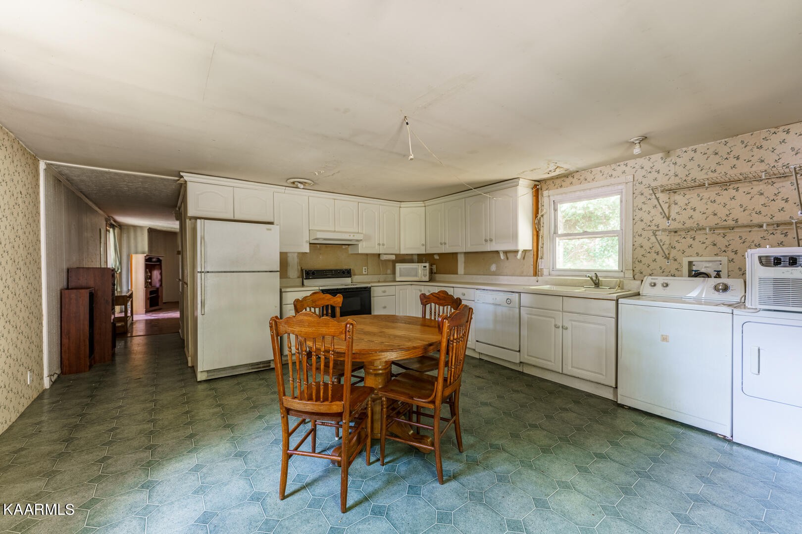 203 Duggan Road Lenoir City, TN 37771 - Photo 10 of 16 a kitchen with a dining table chairs refrigerator and cabinets