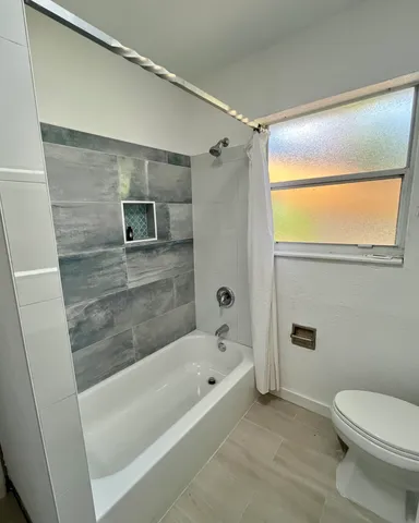 a bathroom with a bathtub a toilet and a shower