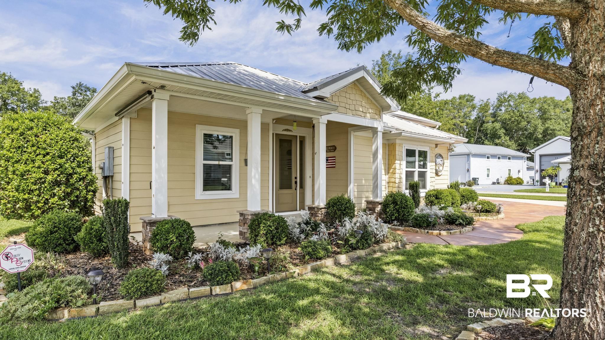 12361 Reunion Place Foley, AL 36535 - Photo 2 of 43 View of front facade with a metal roof, a front lawn, and covered porch