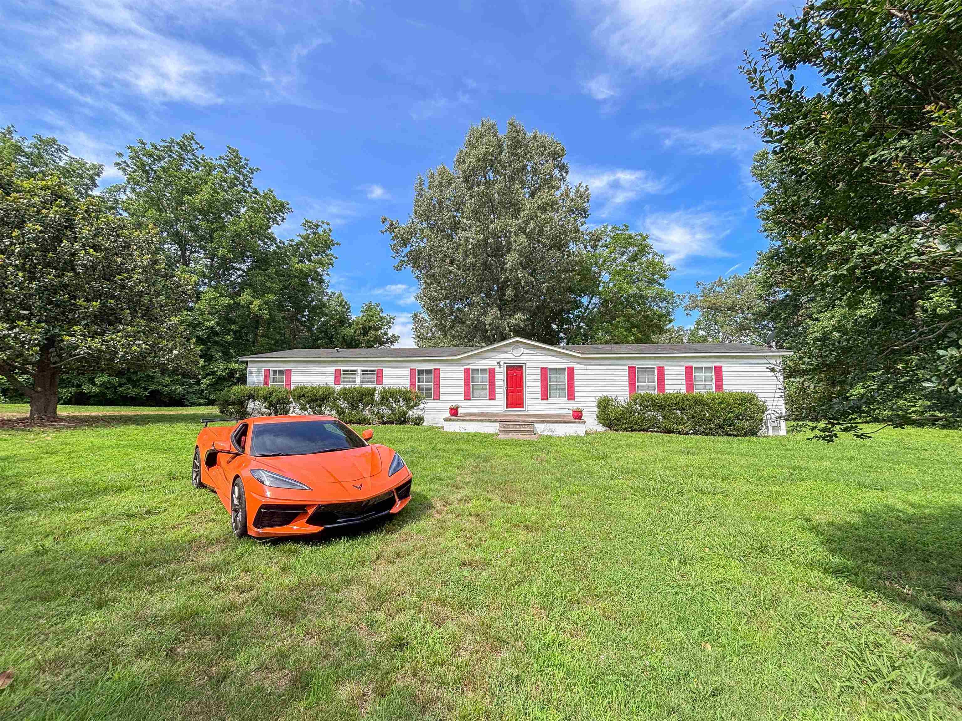 2847 Holly Grove Road Covington, TN 38019 - Photo 2 of 36 Single-story residence featuring a white exterior with red shutters, a red front door, and a covered entry