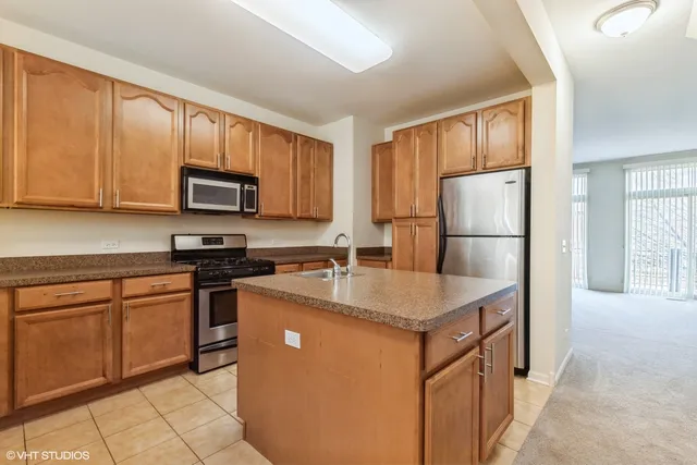 a kitchen with stainless steel appliances granite countertop a refrigerator stove microwave and sink