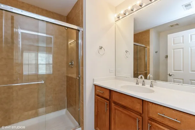 a bathroom with a shower sink and mirror
