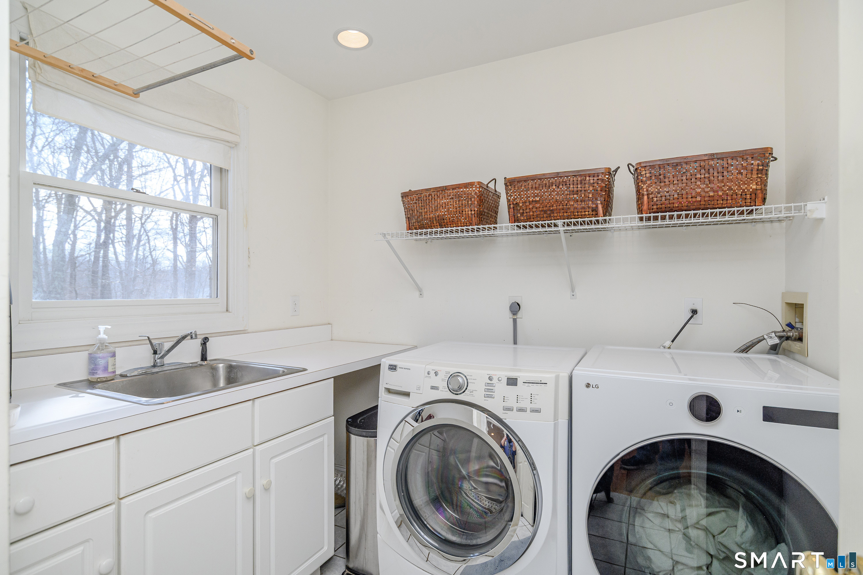 20 Charter Ridge Drive Newtown, CT 06482 - Photo 19 of 40 Beyond the half bathroom is a large laundry room with storage and sink.