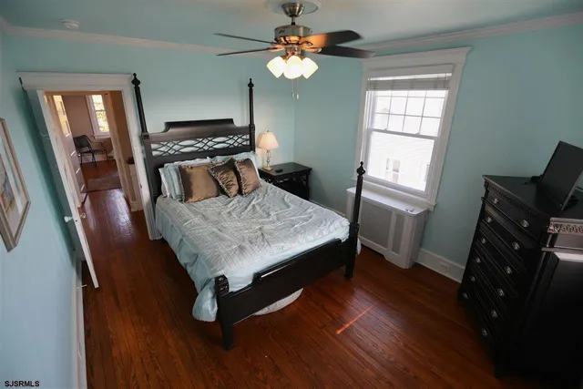 a bedroom with a bed and a tv on the dresser