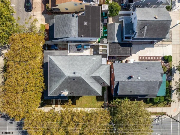 an aerial view of residential houses with outdoor space and parking