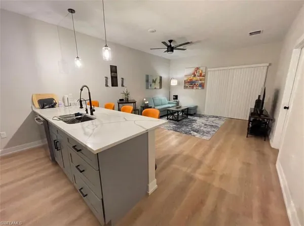 a kitchen that has a sink a stove and a wooden floor