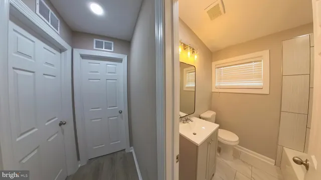 a bathroom with a toilet sink and mirror