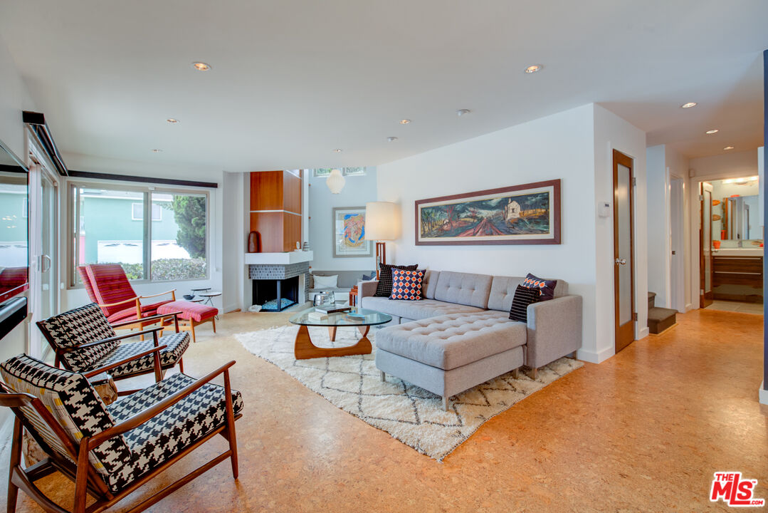 a living room with fireplace furniture and a large window