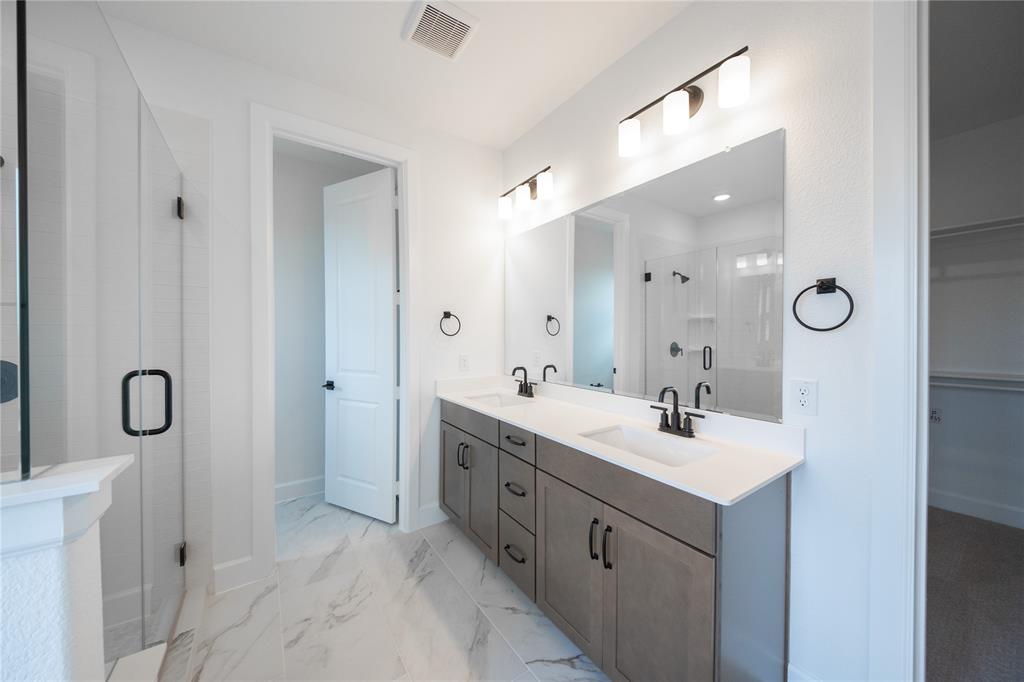 2715 Triumph Court Heath, TX 75126 - Photo 10 of 30 a bathroom with a double vanity sink mirror and shower