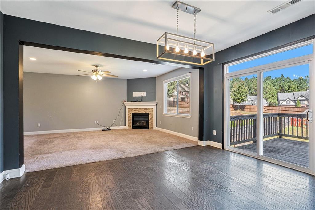 115 Floating Leaf Way Dallas, GA 30132 - Photo 12 of 47 an empty room with wooden floor chandelier and fireplace