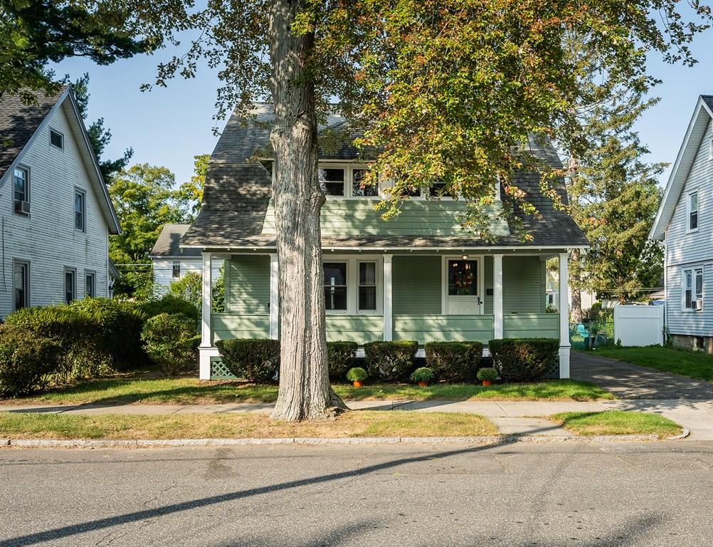 a view of a house with a yard and large tree