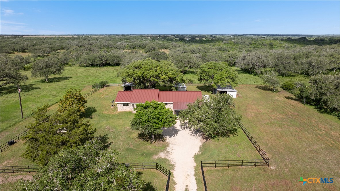 an aerial view of residential houses with outdoor space and trees