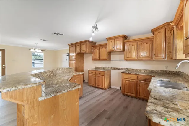 a kitchen with stainless steel appliances granite countertop a sink stove and wooden cabinets