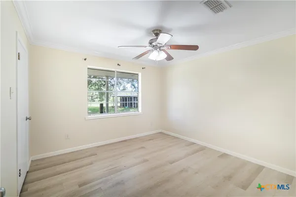 an empty room with a window and a fan