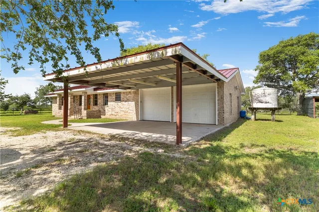 a view of a house with backyard and tree