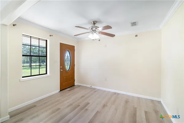 an empty room with windows and fan