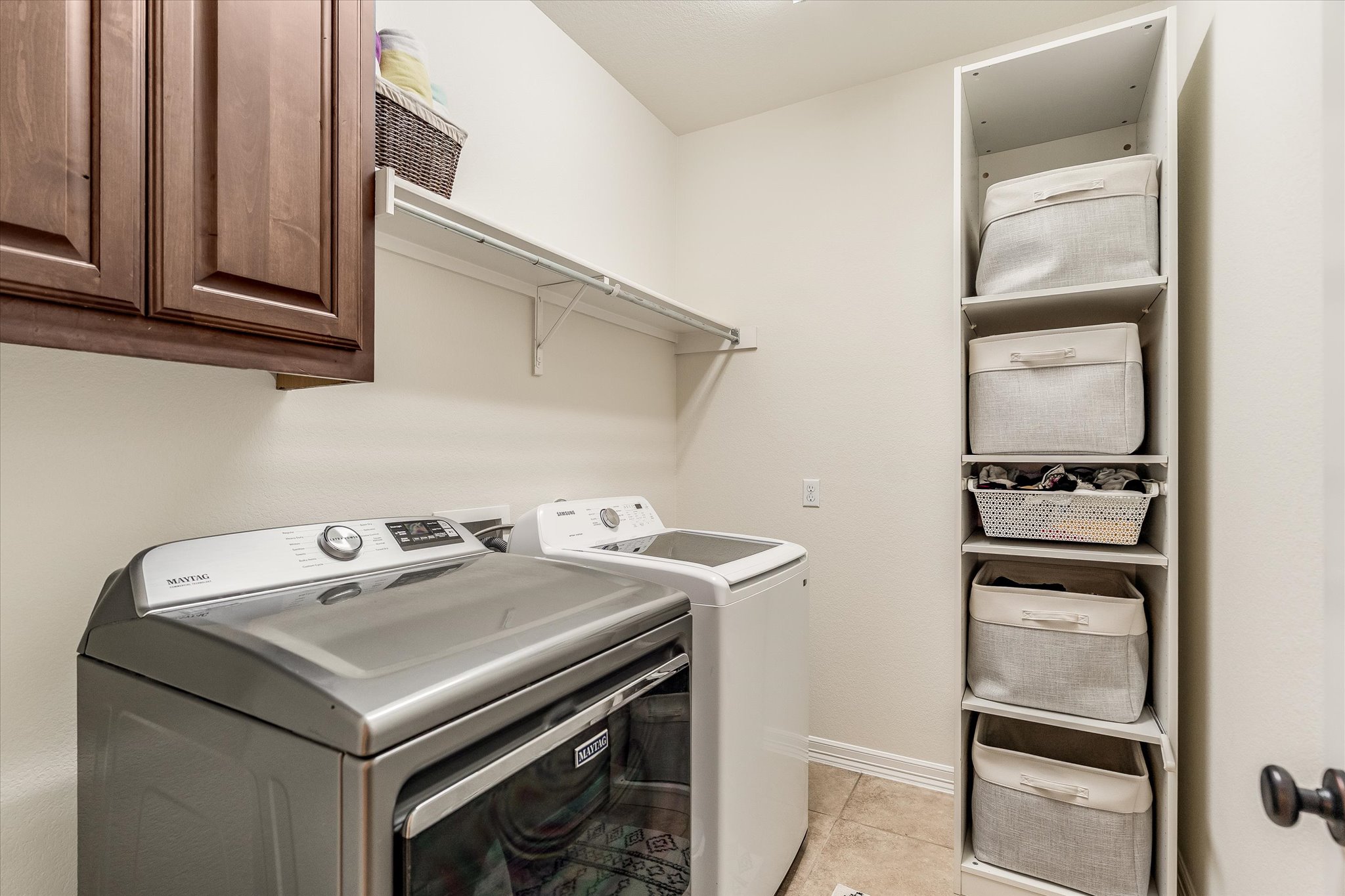 226 Galloway Lane Austin, TX 78737 - Photo 14 of 30 Laundry area with washing machine and clothes dryer, light tile patterned flooring, and cabinet space