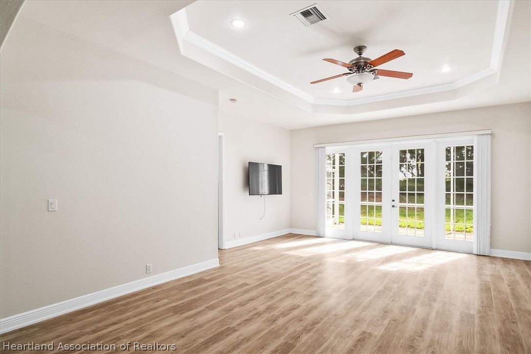 5224 Haw Branch Road Sebring, FL 33875 - Photo 12 of 40 a view of an empty room with a window and wooden floor