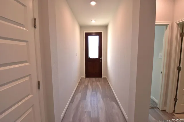 a view of a hallway with wooden floor and closet