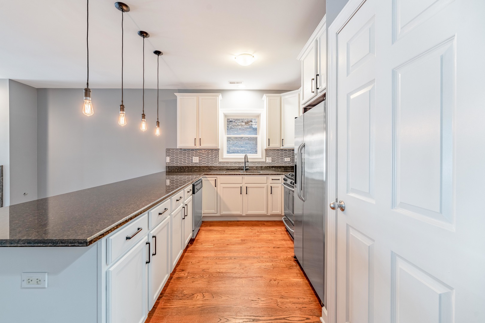 4011 West Fullerton Avenue, Unit 2E Chicago, IL 60639 - Photo 11 of 32 a large kitchen with stainless steel appliances lots of white cabinets