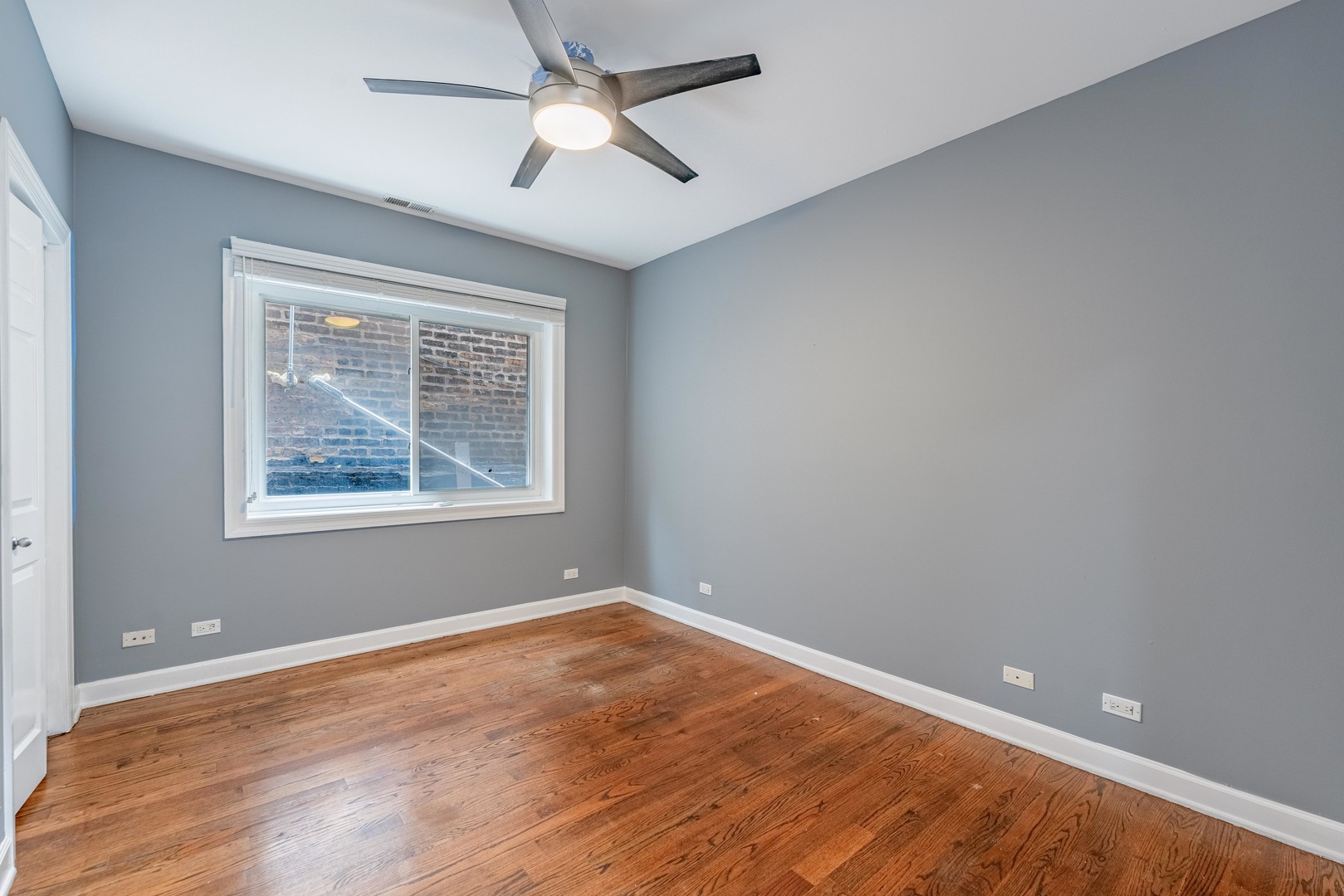 4011 West Fullerton Avenue, Unit 2E Chicago, IL 60639 - Photo 14 of 32 wooden floor in an empty room with a window
