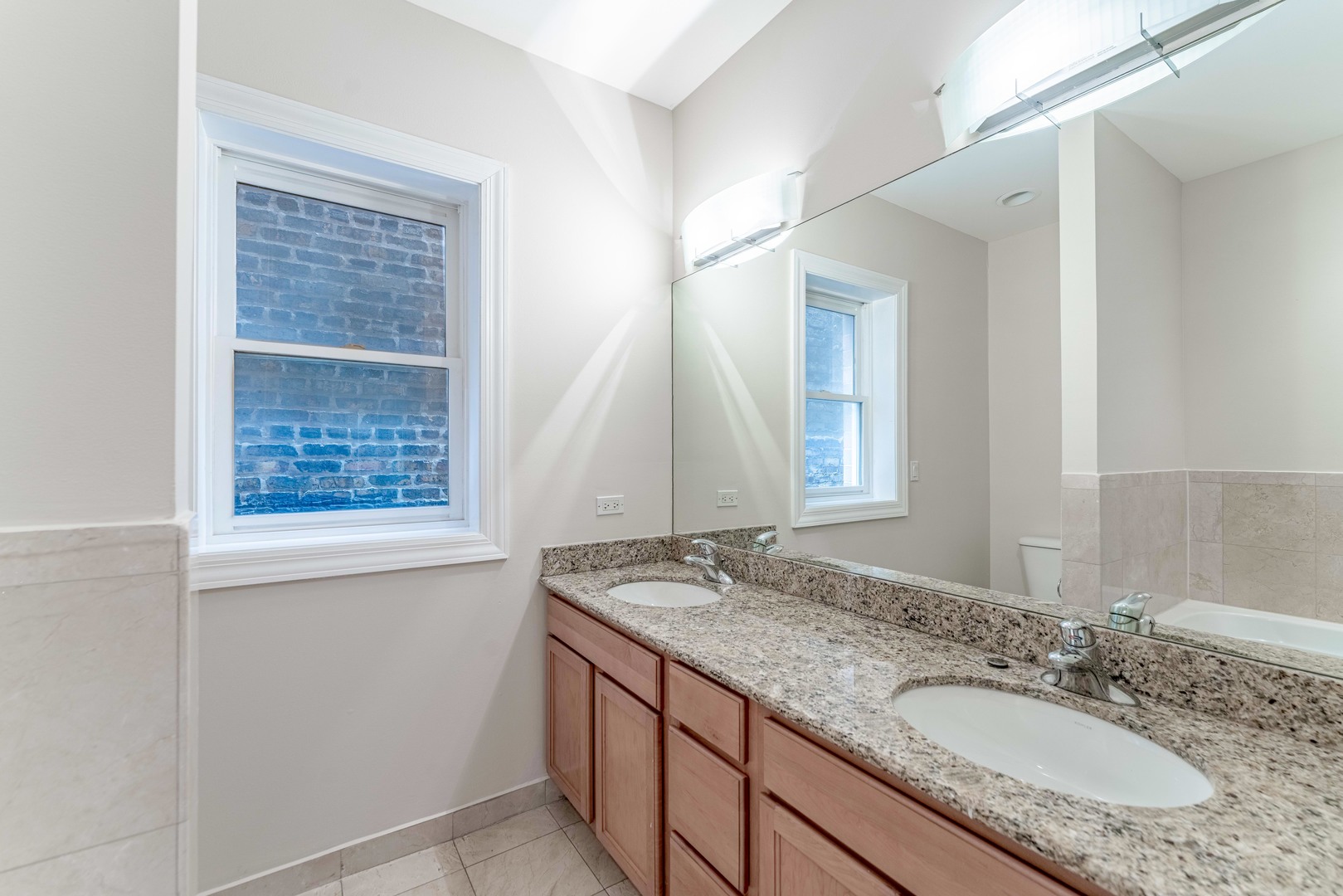 4011 West Fullerton Avenue, Unit 2E Chicago, IL 60639 - Photo 23 of 32 a bathroom with a granite countertop sink and a mirror
