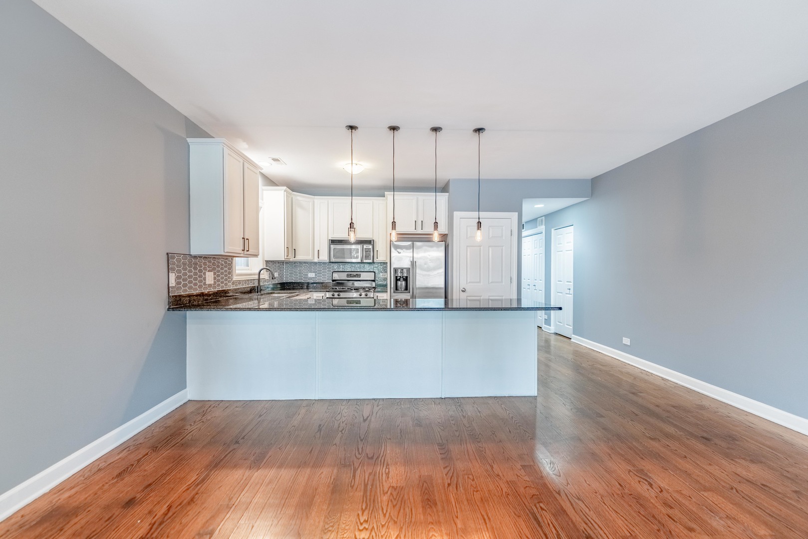 4011 West Fullerton Avenue, Unit 2E Chicago, IL 60639 - Photo 6 of 32 a view of a kitchen with wooden floor