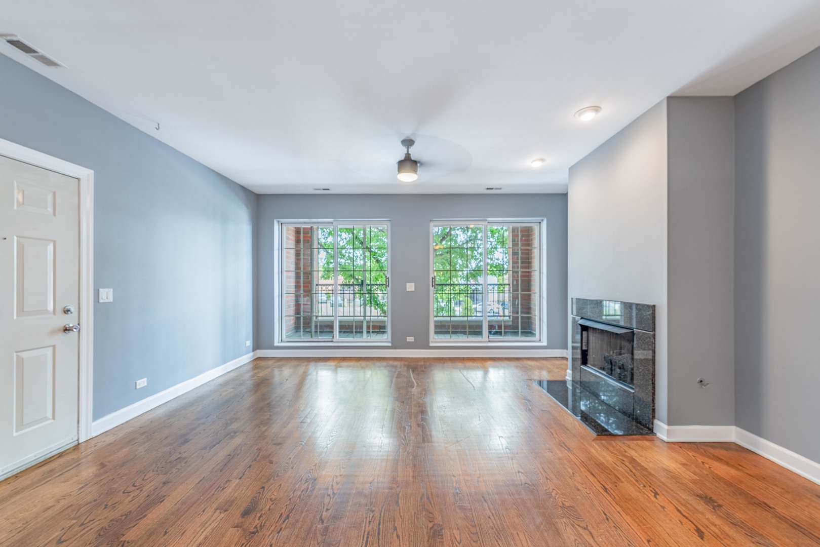 4011 West Fullerton Avenue, Unit 2E Chicago, IL 60639 - Photo 9 of 32 a view of an empty room with wooden floor and a window