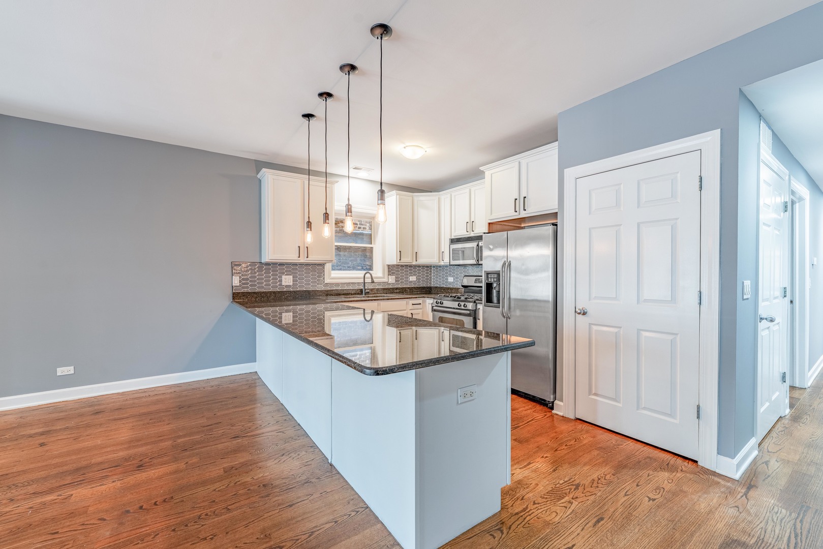 4011 West Fullerton Avenue, Unit 2E Chicago, IL 60639 - Photo 10 of 32 a kitchen with stainless steel appliances granite countertop a sink a stove a refrigerator and island with wooden floor