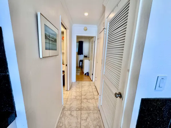 a view of a hallway with a livingroom and a bathroom with sink