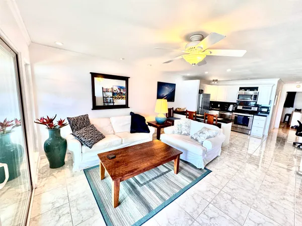 a living room with furniture a rug and a dining table with wooden floor