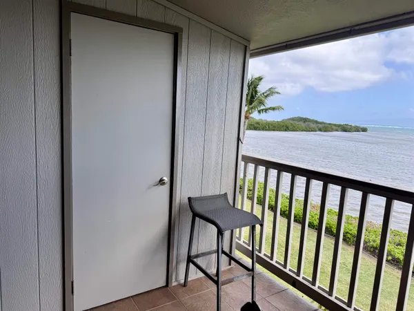 a view of a balcony with furniture and a gate