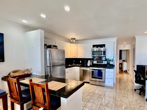 a kitchen with stainless steel appliances granite countertop a refrigerator and a stove top oven