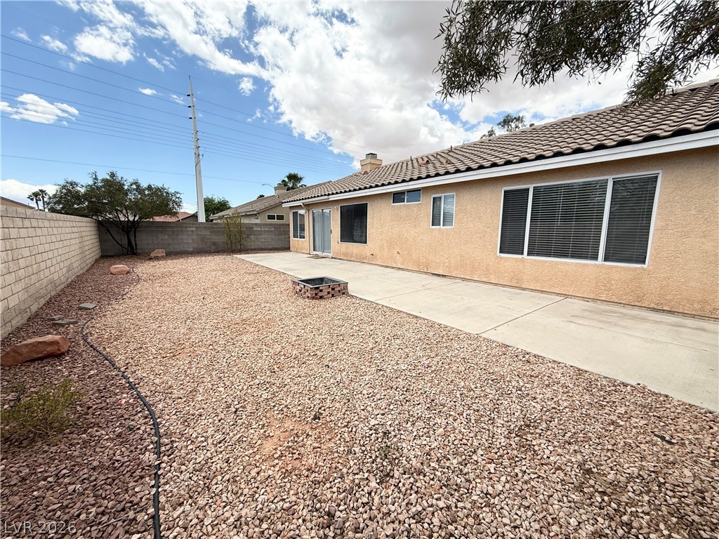 8870 Haviland Road Las Vegas, NV 89123 - Photo 24 of 24 An arid backyard features a concrete patio and a built-in fire pit.