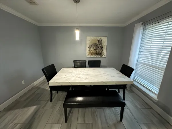 a view of a dining room with a table and chairs