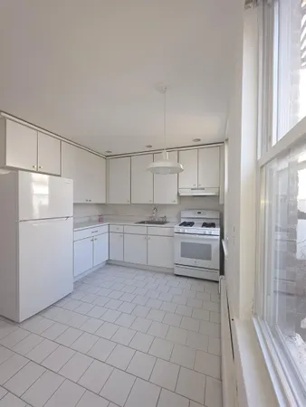 a kitchen with white cabinets and white appliances