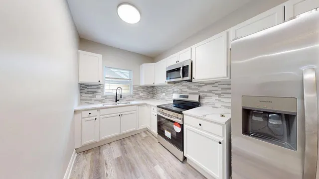a kitchen with granite countertop a sink stove and microwave