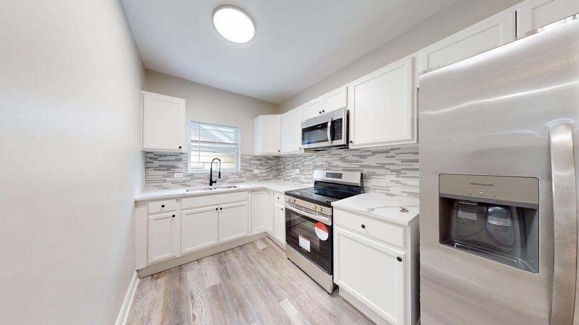1379 Roosevelt Place, Unit 1 Gary, IN 46404 - Photo 18 of 24 a kitchen with granite countertop a sink stove and microwave