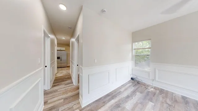 a view of a hallway with wooden floor and entryway