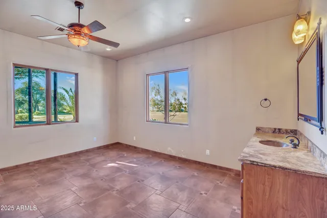 an empty room with fan and windows