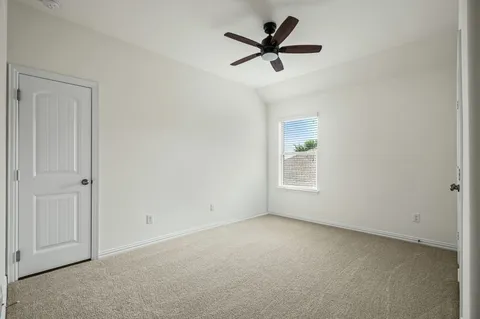 an empty room with a ceiling fan and window