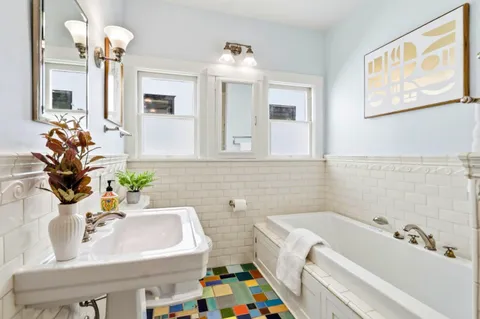 a bathroom with a sink mirror and a bathtub