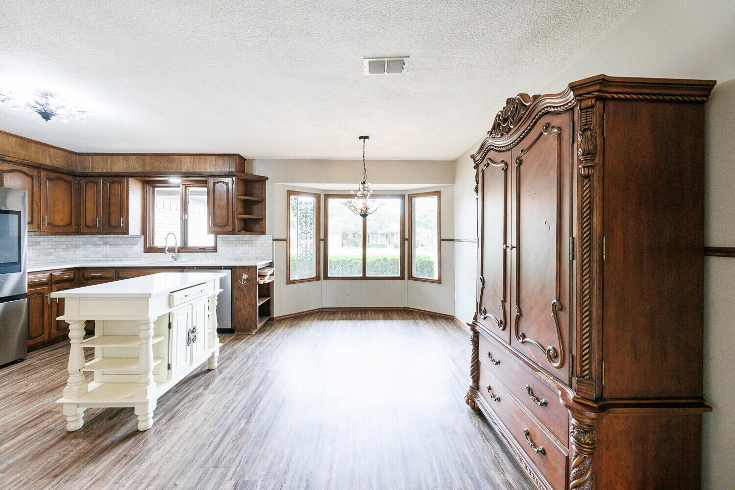 5703 80th Street Lubbock, TX 79424 - Photo 11 of 52 a kitchen with granite countertop a refrigerator a sink and wooden floors
