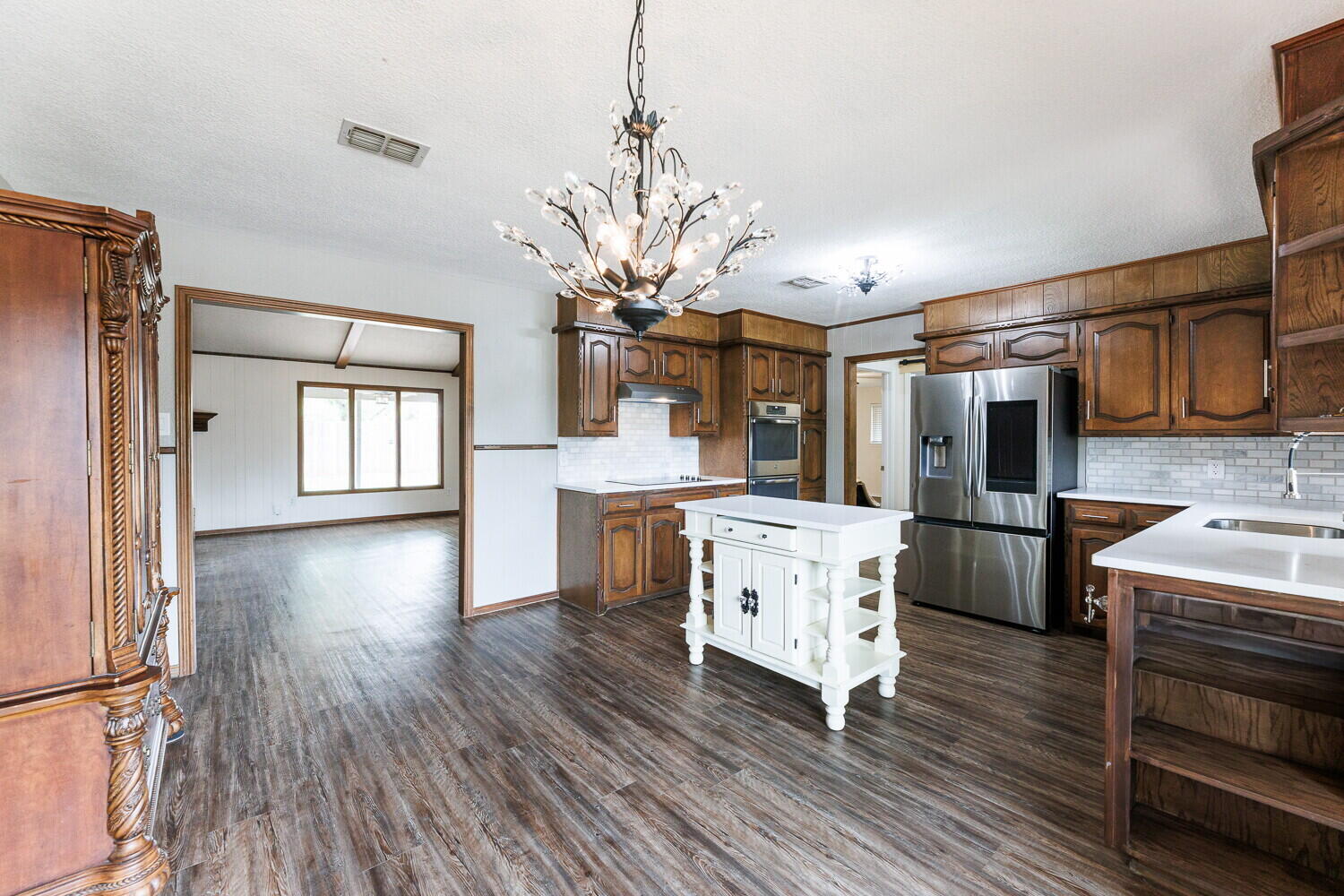 5703 80th Street Lubbock, TX 79424 - Photo 13 of 52 a kitchen with stainless steel appliances granite countertop a refrigerator a stove top oven a sink dishwasher and white cabinets with wooden floor