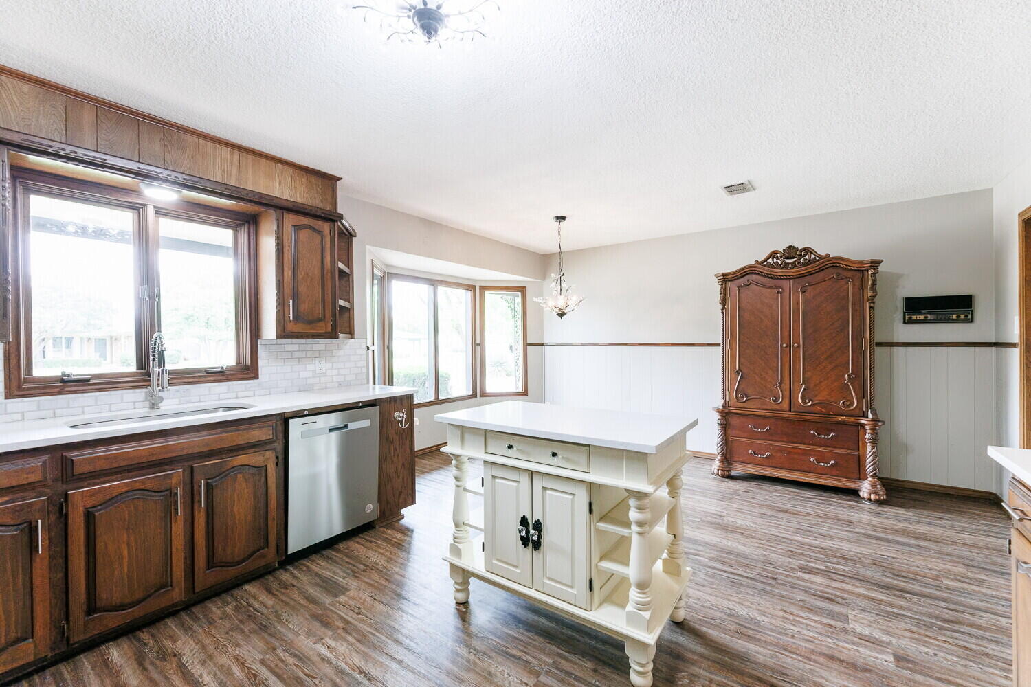 5703 80th Street Lubbock, TX 79424 - Photo 15 of 52 a open kitchen with stainless steel appliances granite countertop a stove a sink dishwasher and a refrigerator with wooden floor