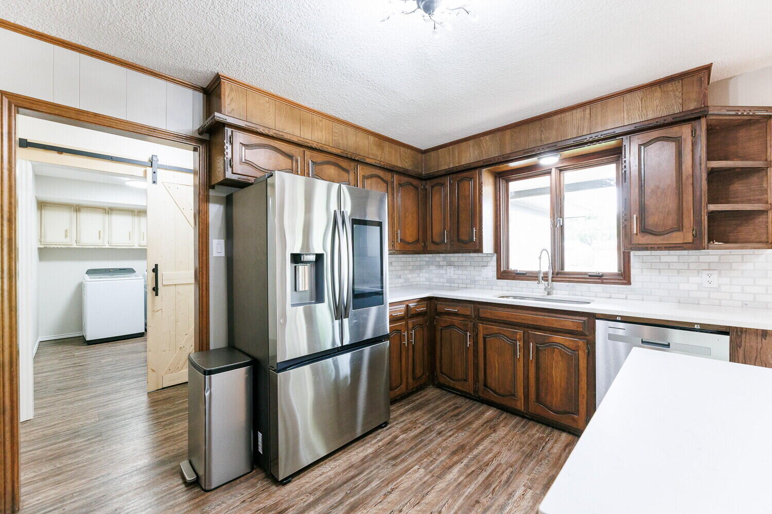 5703 80th Street Lubbock, TX 79424 - Photo 20 of 52 a kitchen with stainless steel appliances granite countertop a refrigerator a sink and dishwasher with wooden floor
