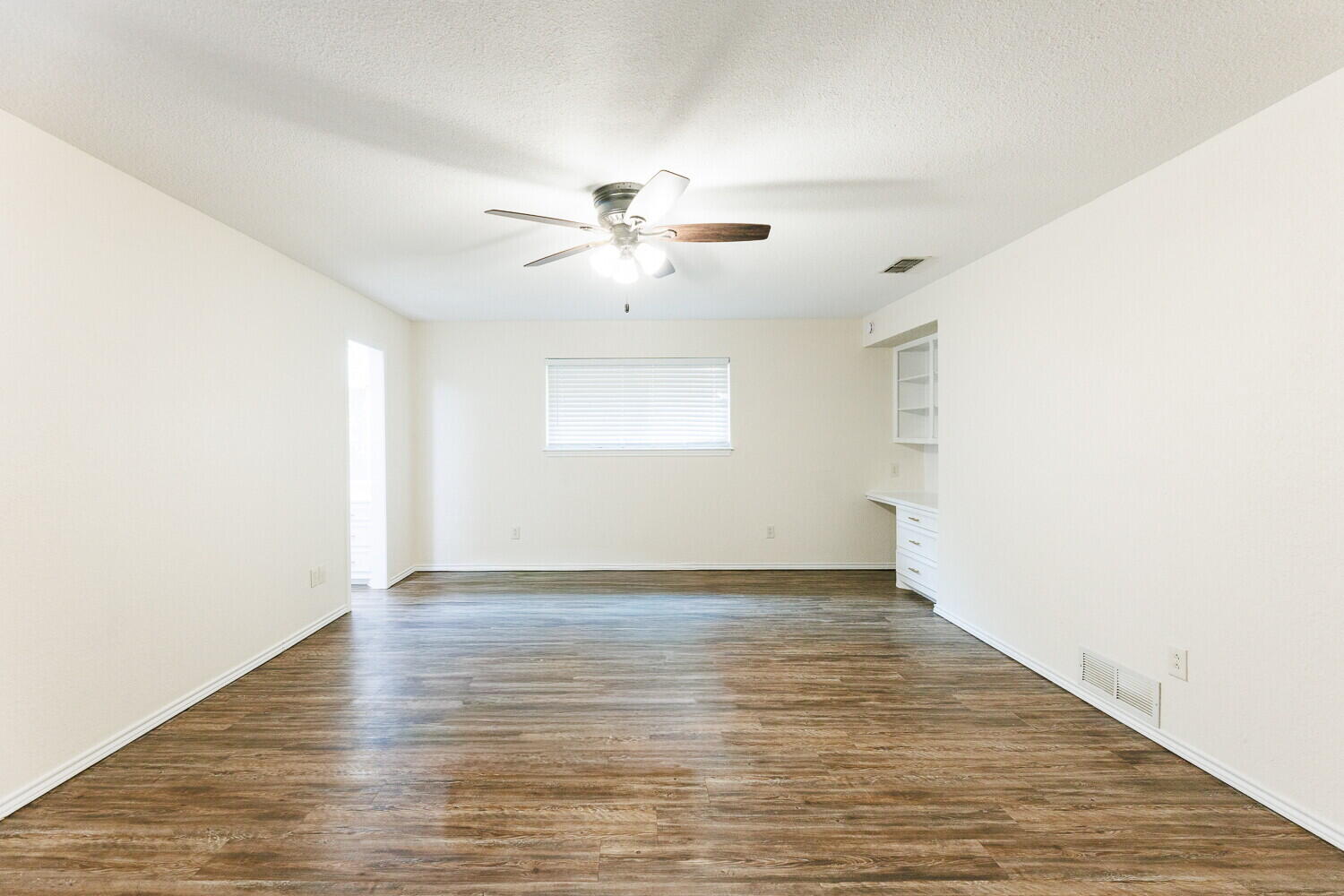 5703 80th Street Lubbock, TX 79424 - Photo 24 of 52 a view of empty room with wooden floor and fan